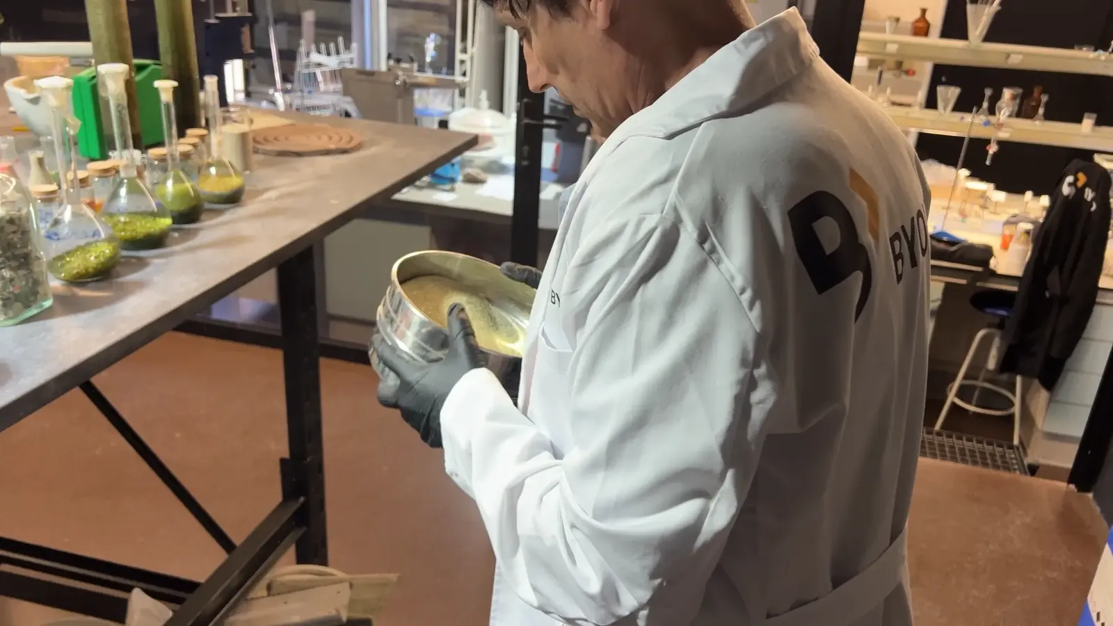 Técnico de Byond Canarias tamizando árido de vidrio reciclado en el laboratorio