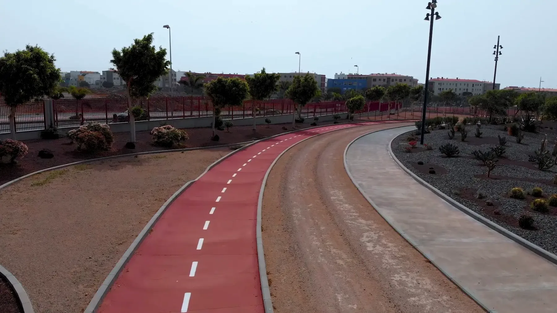 Carril bici con pavimento Zoruflex Tráfico rojo y líneas blancas en parque urbano de Gran Canaria