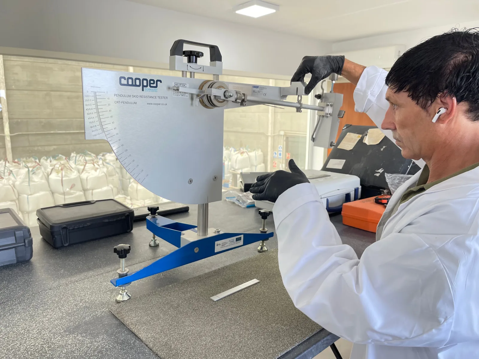Técnico de Byond acondicionando el péndulo de resbaladicidad Cooper CRT sobre la muestra de pavimento