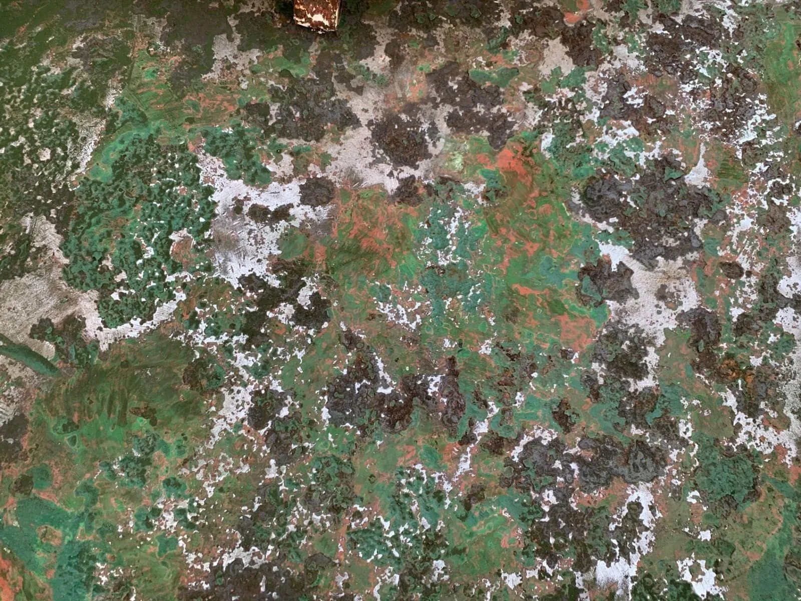 Detalle macro de cubierta naval con óxido, pintura desconchada y manchas