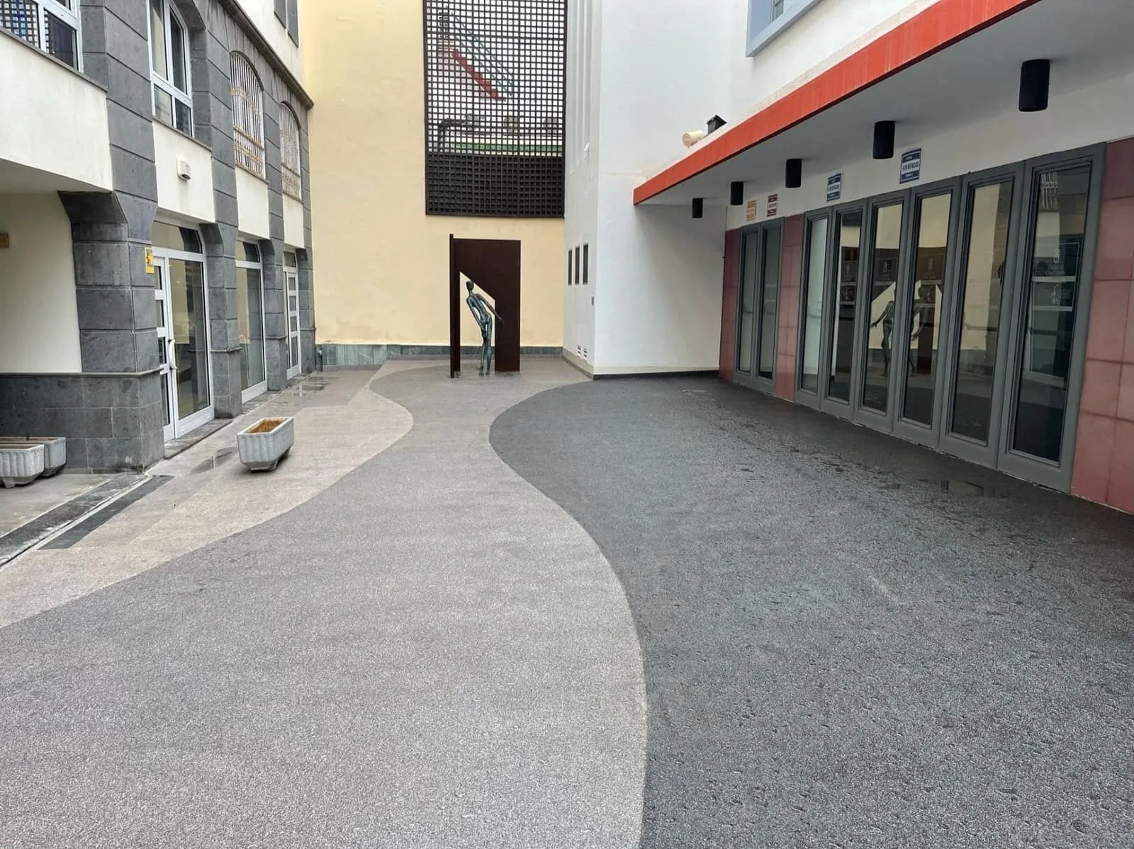 Patio del Teatro Cuyás con pavimento impermeabilizado y trazado curvo bicolor
