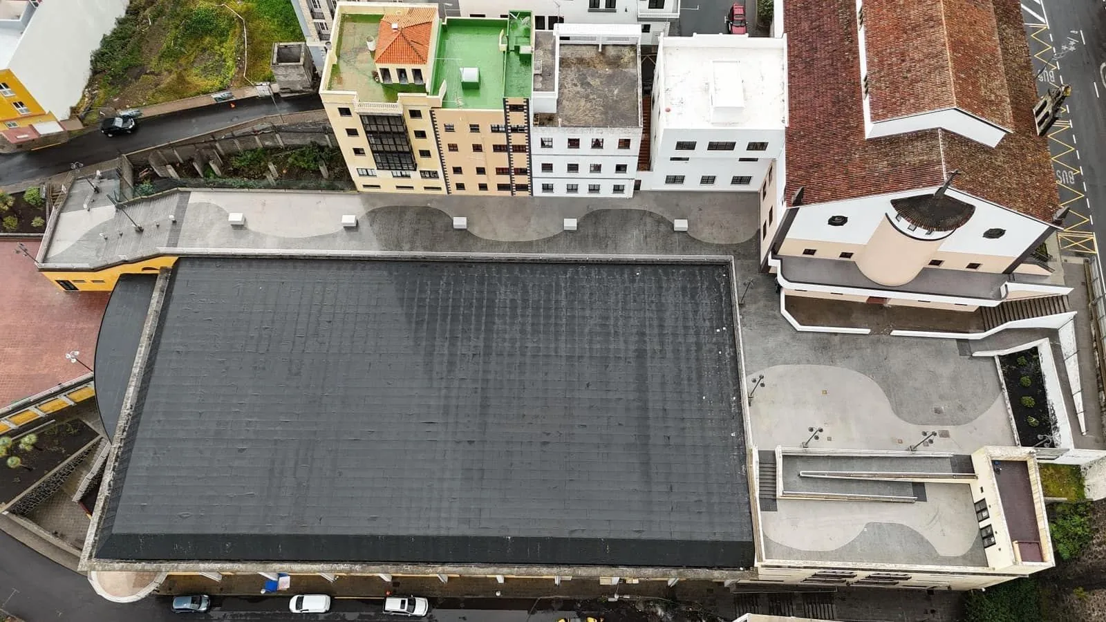 Vista cenital de plaza pública impermeabilizada con composición curva en el pavimento