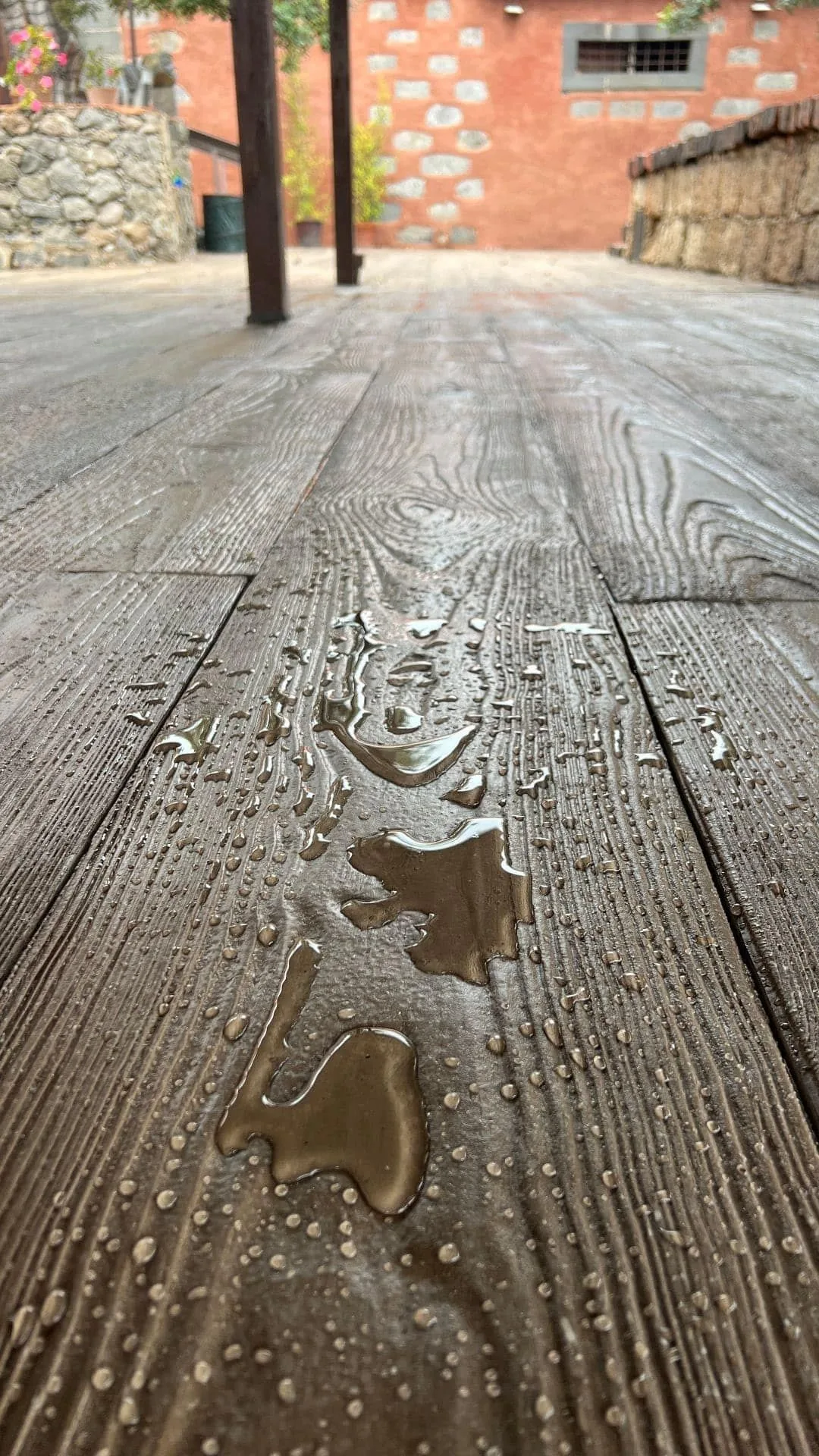 Detalle macro de la baldosa Zoruflex acabado madera con gotas de agua sobre la veta