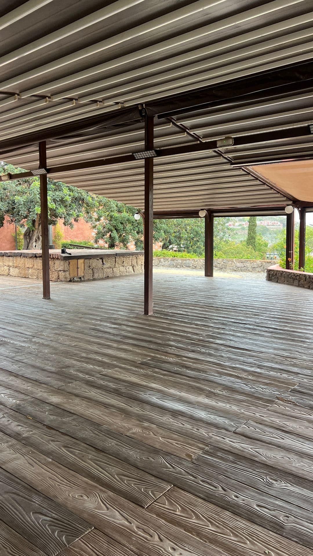 Espacio diáfano bajo pérgola con baldosa Zoruflex acabado madera en formato tablón