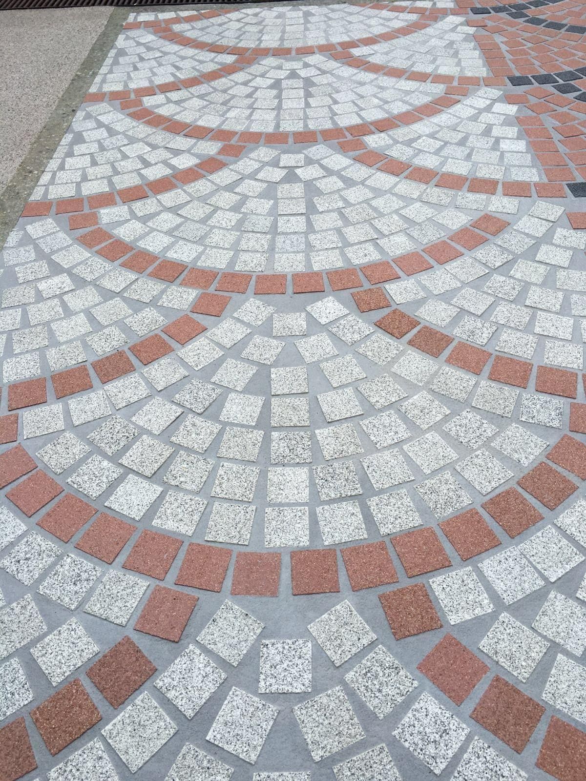 Pavimento Zoruflex en composición de abanicos circulares en blanco granítico y rojo