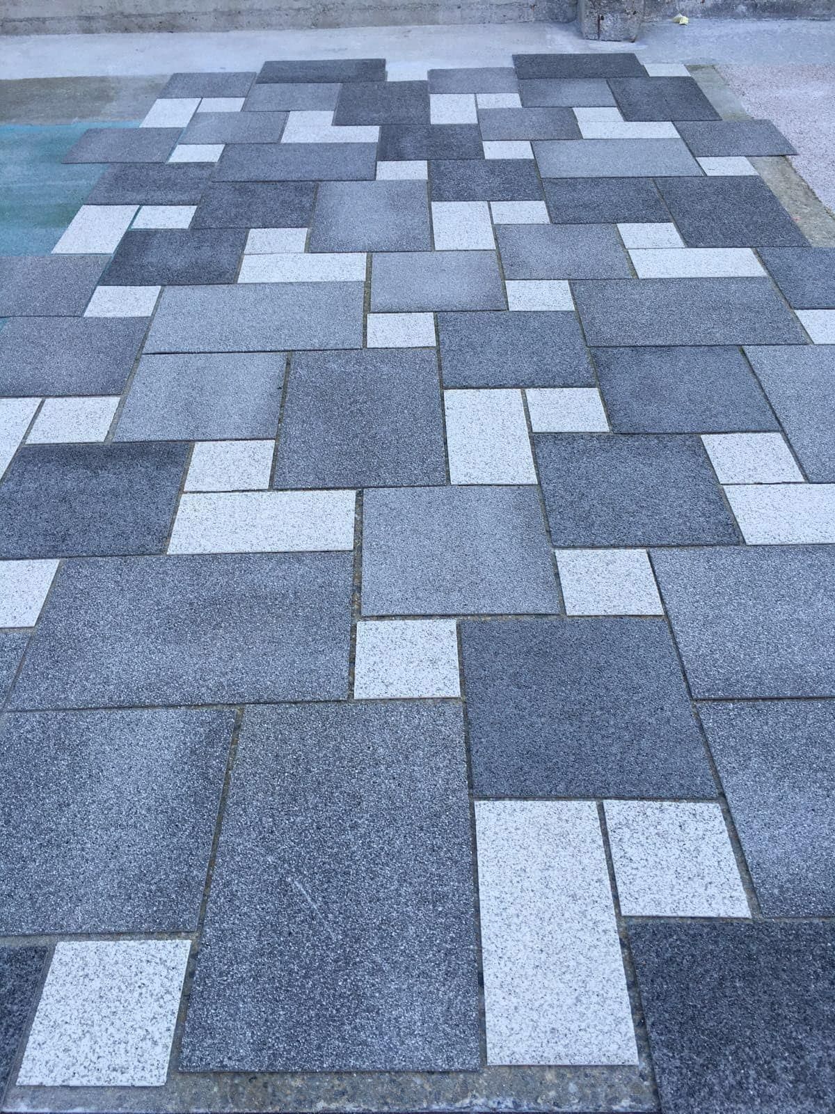 Pavimento Zoruflex en composición rectangular con piezas en distintos tonos de gris y blanco
