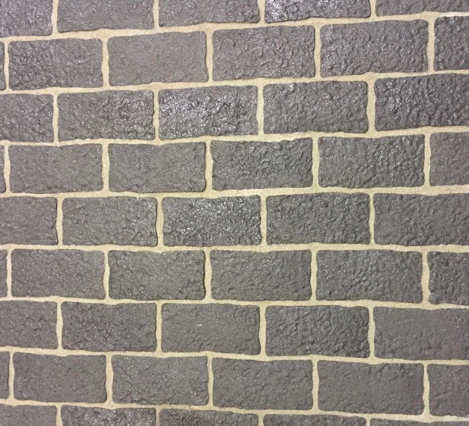 Muro de baldosa Zoruflex con acabado ladrillo gris rugoso y junta beige